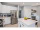 Kitchen area showcasing white cabinetry, stainless steel appliances, and an island with seating at 6039 S Ukraine Cir, Aurora, CO 80015
