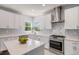 Well-lit kitchen with white cabinets, stainless steel appliances, quartz countertops, and backsplash detailing at 6039 S Ukraine Cir, Aurora, CO 80015