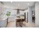 Bright, open kitchen with white cabinets, stainless steel appliances, and a central island with breakfast bar at 6039 S Ukraine Cir, Aurora, CO 80015