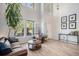 Spacious living room with two-story ceilings, natural light, wood flooring, and cozy seating arrangements at 6039 S Ukraine Cir, Aurora, CO 80015