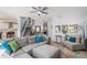 Comfortable living room with a large sectional sofa, a ceiling fan and view of the stairway and front entrance at 6039 S Ukraine Cir, Aurora, CO 80015