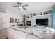 Spacious living room with fireplace, custom built-in shelves, and ample seating space with comfortable furnishings at 6039 S Ukraine Cir, Aurora, CO 80015