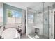 Luxurious main bathroom with a soaking tub, a walk-in shower, and natural light from the window at 6039 S Ukraine Cir, Aurora, CO 80015