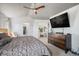 Serene main bedroom with a ceiling fan, a large television, and a view of the closet and attached room at 6039 S Ukraine Cir, Aurora, CO 80015