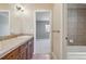 Bathroom featuring tile floors, wood cabinets, tiled shower and view into bedroom at 2975 E Wesley Ave, Denver, CO 80210