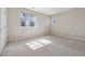 Cozy bedroom with neutral carpet, white walls, and two windows allowing ample sunlight at 2975 E Wesley Ave, Denver, CO 80210