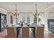 Elegant dining room featuring modern chandeliers, a fireplace, and a backyard view at 2975 E Wesley Ave, Denver, CO 80210