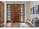 Elegant foyer with wood-look tile flooring, a stained wood door, and a cozy bench at 2975 E Wesley Ave, Denver, CO 80210