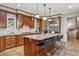 Spacious kitchen features wooden cabinetry, a large island with seating, and pendant lighting at 2975 E Wesley Ave, Denver, CO 80210