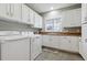 Bright laundry room featuring white cabinets and a utility sink with a view at 2975 E Wesley Ave, Denver, CO 80210