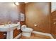 Elegant powder room with decorative walls, tiled floor, and a modern sink and toilet at 2975 E Wesley Ave, Denver, CO 80210