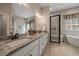 Primary bathroom featuring a soaking tub, double vanity, and walk-in shower at 672 W 128Th Pl, Westminster, CO 80234