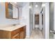 Bathroom featuring a wooden vanity, neutral walls, and a doorway leading to a tiled shower at 4634 S Fraser Ct # F, Aurora, CO 80015