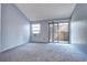 Bedroom with neutral carpet, a window AC unit, and sliding glass doors to the patio at 4634 S Fraser Ct # F, Aurora, CO 80015