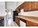Classic kitchen features wood cabinets, appliances, and tile flooring with a door to the laundry room at 4634 S Fraser Ct # F, Aurora, CO 80015