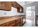 Classic kitchen features wood cabinets, appliances, and tile flooring with a view to the living room at 4634 S Fraser Ct # F, Aurora, CO 80015
