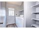 View of laundry room with shelving, washer, dryer, and a door to the exterior of the home at 4634 S Fraser Ct # F, Aurora, CO 80015