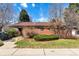 Charming brick home features a well-manicured lawn and mature trees under a sunny blue sky at 6101 E 3Rd Ave, Denver, CO 80220