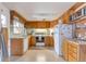 Functional kitchen with wooden cabinets, white appliances, and ample counter space at 6101 E 3Rd Ave, Denver, CO 80220