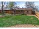Grassy backyard surrounded by wood fences and mature trees at 4250 Marshall St, Wheat Ridge, CO 80033