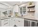 Modern kitchen boasts white cabinets, stainless steel appliances, and view to the outdoors at 4250 Marshall St, Wheat Ridge, CO 80033