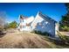 View of the home's rear elevation with a walkway around the perimeter, and partial grass backyard at 935 Green Gables Cir, Bennett, CO 80102