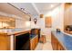 Basement bar area features custom wood cabinets, lighting, and a small refrigerator for entertaining at 935 Green Gables Cir, Bennett, CO 80102