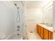 Bathroom featuring a shower-tub combination with white tiled walls and a double sink vanity with oak cabinets at 935 Green Gables Cir, Bennett, CO 80102