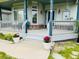Charming covered front porch with decorative plants, creating an inviting entrance at 935 Green Gables Cir, Bennett, CO 80102
