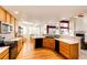 Well-lit kitchen featuring stainless steel appliances, wood floors, and adjacent dining area at 935 Green Gables Cir, Bennett, CO 80102