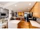 Open-concept kitchen with bar seating, wooden cabinets, and appliances, flowing into the dining area at 935 Green Gables Cir, Bennett, CO 80102