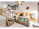 Bright living room with a vaulted ceiling, carpet floors and view into the adjacent kitchen at 935 Green Gables Cir, Bennett, CO 80102