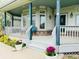 Charming covered front porch with ample seating and decorative flower pots at 935 Green Gables Cir, Bennett, CO 80102