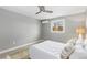 Cozy bedroom with a window, ceiling fan, air conditioner, and comfortable white bedding at 159 Judson St, Longmont, CO 80501