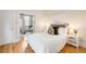 Bright bedroom with white bedding and access to an office, all with hardwood floors at 1767 N Washington St, Denver, CO 80203