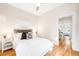 Bright bedroom with white bedding and access to an office, all with hardwood floors and neutral paint at 1767 N Washington St, Denver, CO 80203