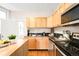 Bright kitchen with wood cabinets, black countertops, stainless steel appliances and hardwood floors at 1767 N Washington St, Denver, CO 80203