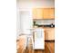Bright kitchen with wood cabinets, black countertops, an island with a butcher block top and hardwood floors at 1767 N Washington St, Denver, CO 80203