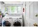 Well-lit laundry room equipped with washer, dryer, and storage space near a bright window at 1767 N Washington St, Denver, CO 80203