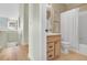 Bathroom with vanity, toilet, and tub/shower combo with white shower curtain at 12961 Lafayette St # B, Thornton, CO 80241