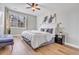 A naturally lit bedroom with hardwood floors and a ceiling fan at 12961 Lafayette St # B, Thornton, CO 80241