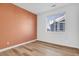 Bright bedroom features stylish laminate floors, large window and neutral paint at 12961 Lafayette St # B, Thornton, CO 80241