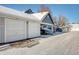 Attached garage with parking spaces and snow covered driveway at 12961 Lafayette St # B, Thornton, CO 80241