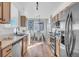 Bright kitchen with stainless steel appliances, light wood cabinets, and a glass top dining table in view at 12961 Lafayette St # B, Thornton, CO 80241