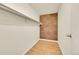 Practical walk-in closet with cork accent wall, wood flooring and shelf at 6980 E Girard Ave # 204, Denver, CO 80224