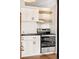 Kitchen with white cabinets, a stainless steel oven, range hood, and butcher block floating shelves at 1617 California St # 3B, Denver, CO 80202