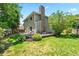 Landscaped backyard with stone chimney, patio, deck, and lush greenery at 4906 S Crystal St, Aurora, CO 80015