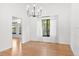 Dining room with hardwood floors, white curtains, a modern light fixture, and a view into the living room at 4906 S Crystal St, Aurora, CO 80015
