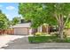 Attractive home exterior showcasing the well-kept lawn, partial privacy fence, and a stone and dark wood facade at 4906 S Crystal St, Aurora, CO 80015