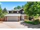 Charming two-story home with a stone and dark wood exterior, a well-maintained lawn, and a two car garage at 4906 S Crystal St, Aurora, CO 80015